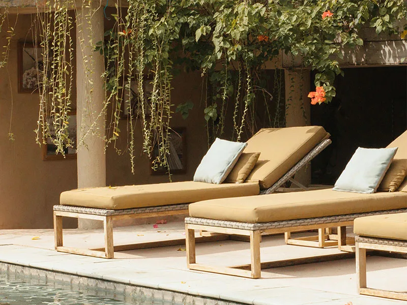 Comfortable sun loungers with cushions beside the pool, surrounded by tropical greenery at Coquí Hideaway